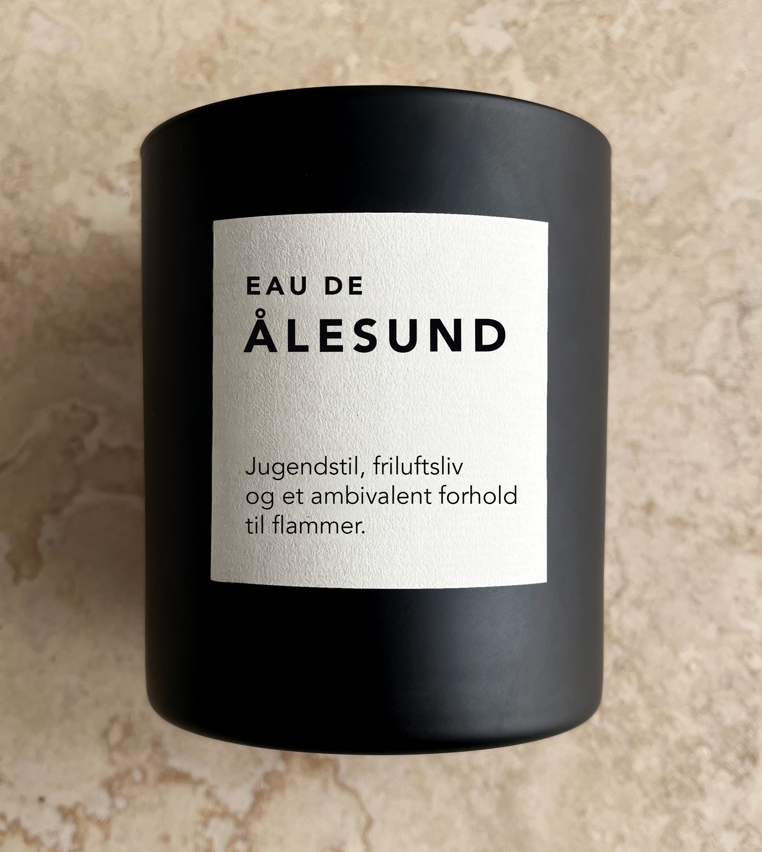 Svart duftlys med Ålesund-etikett på matt beholder